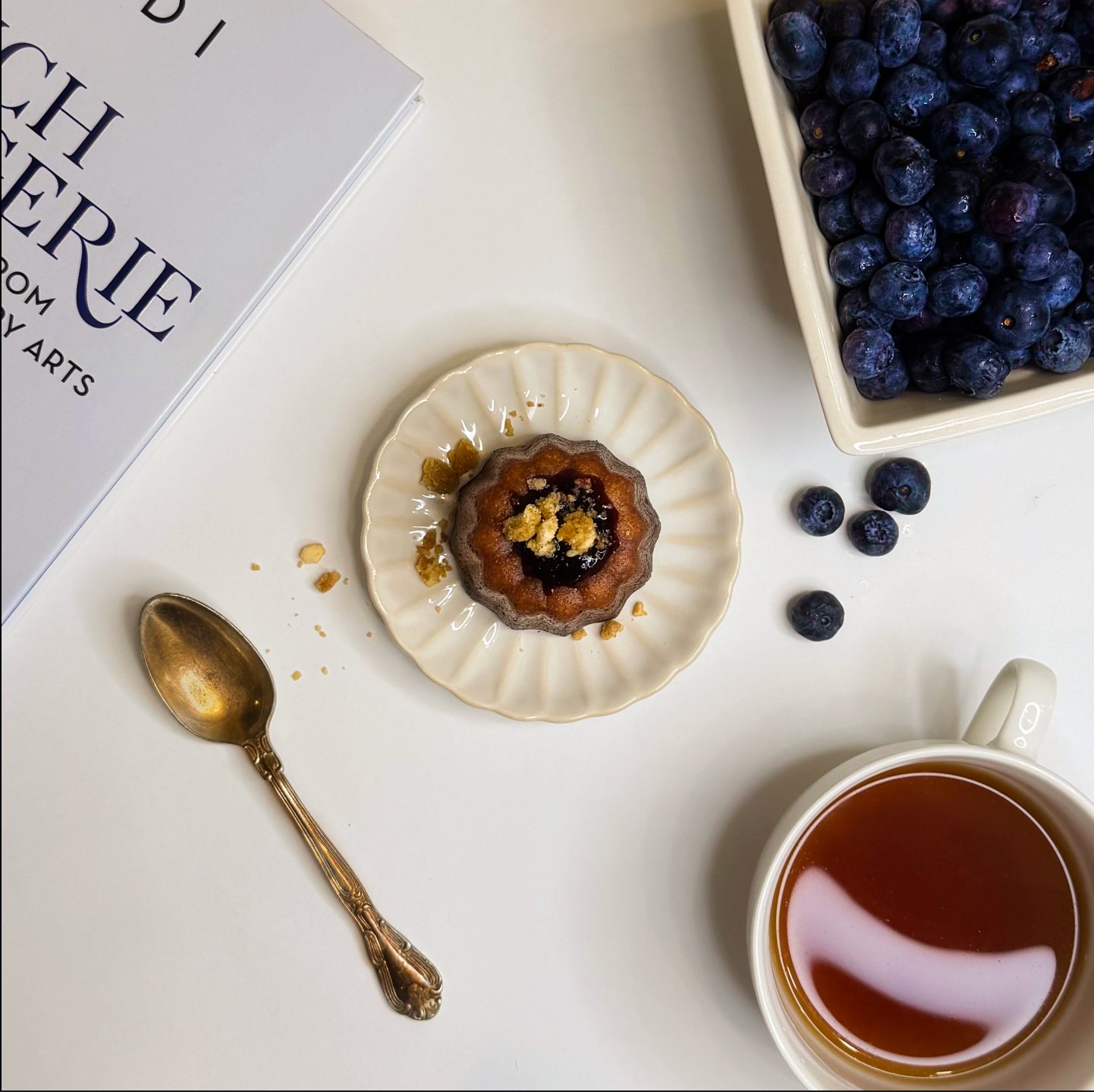 Tea cup with a dessert and blueberries on a white surface